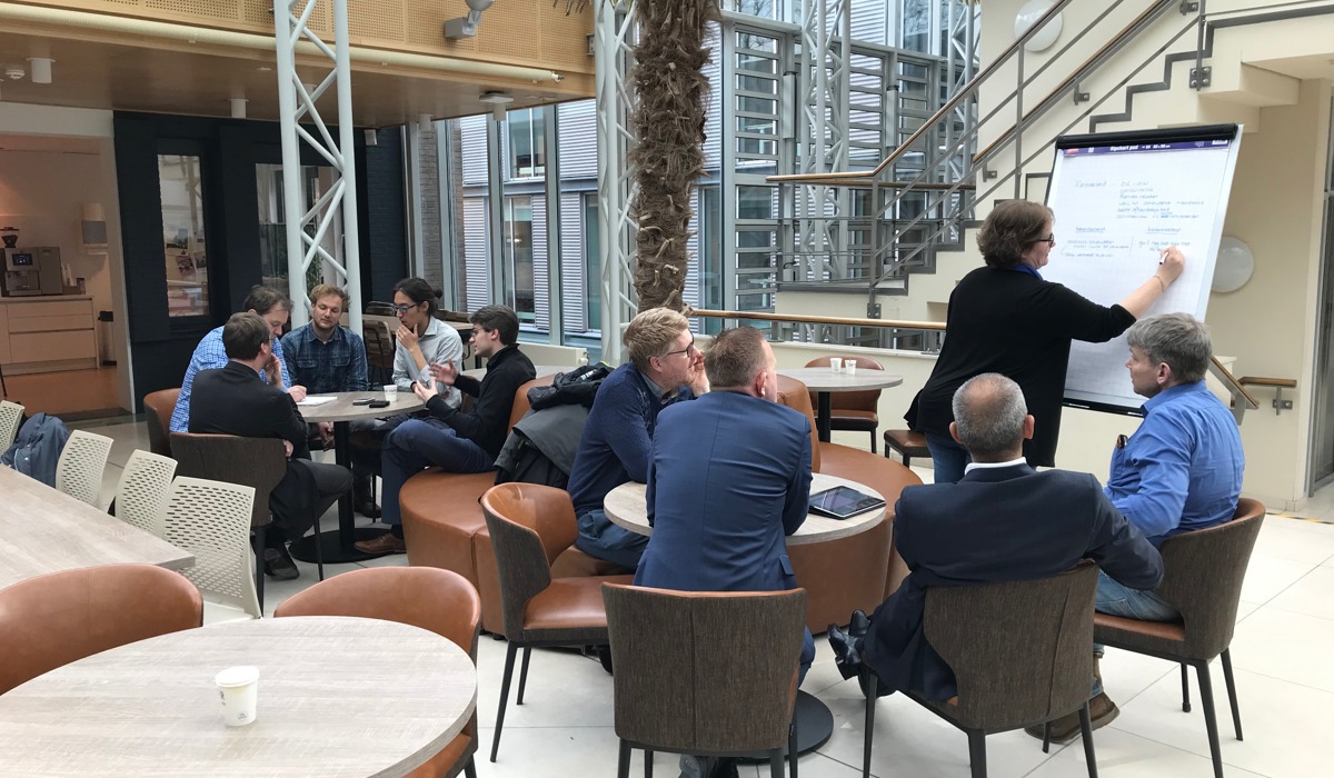 Dit plaatje toont deelnemers rond een flip-over.